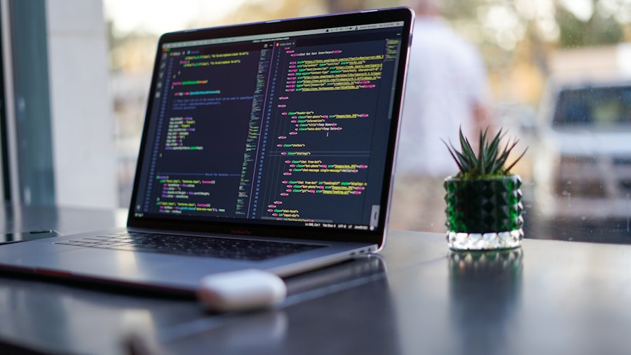 Developer writing front-end code on a laptop screen showing markup and styles